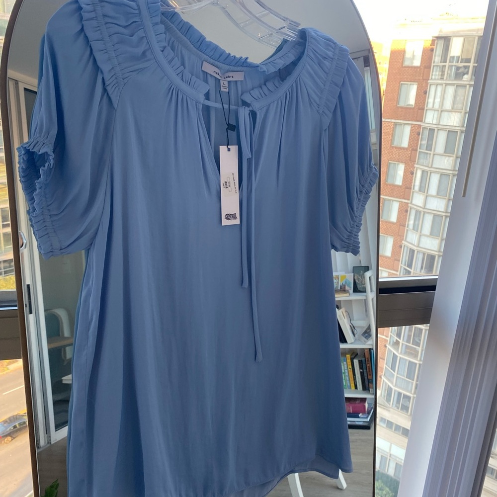 Blue blouse, ties at the neck, ruffle near the collar